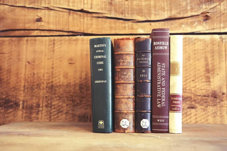 Libros encuadernados en una estantería de madera