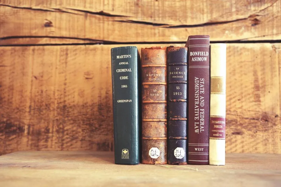 Libros encuadernados en una estantería de madera