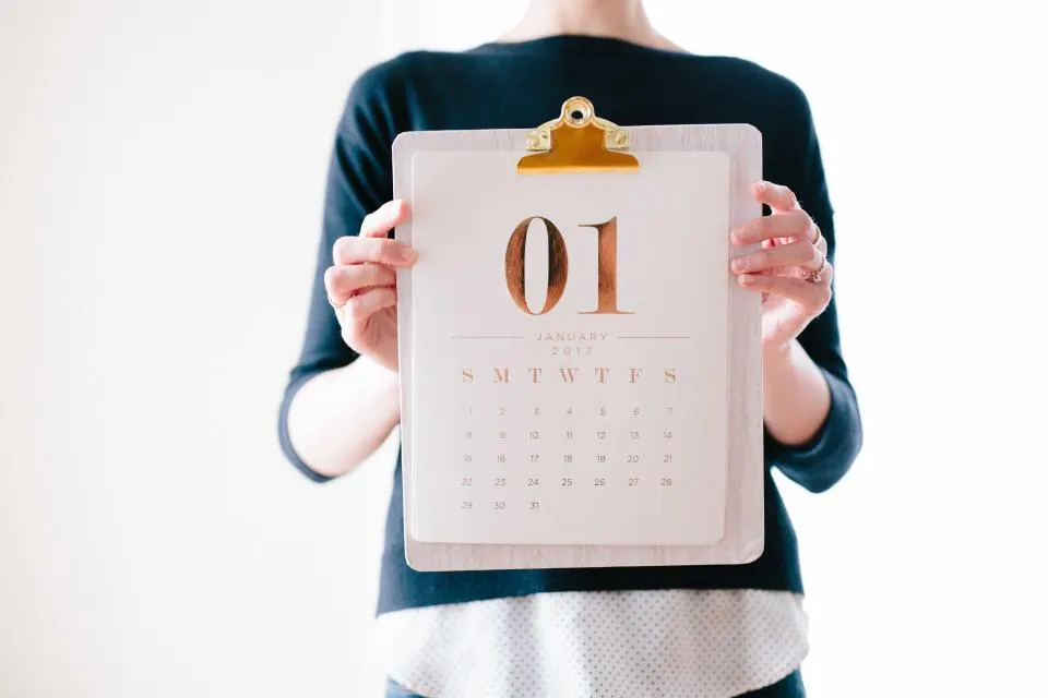 Persona sosteniendo un calendario mensual
