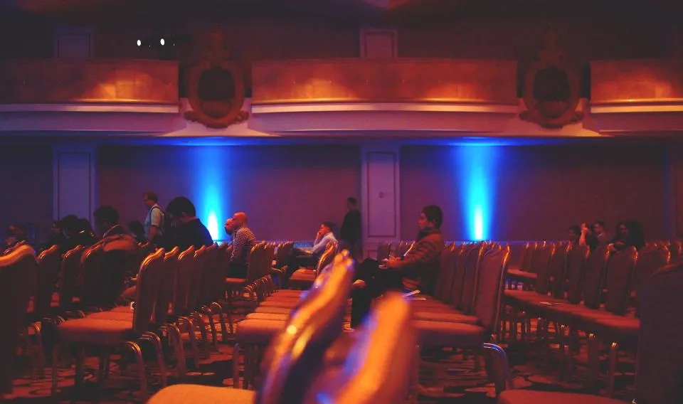Auditorio con público frente a un escenario iluminado