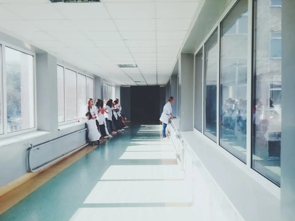 Pasillo luminoso de un hospital con profesionales al fondo